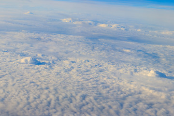 Beautiful white clouds in blue sky. View from airplane