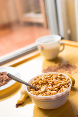 Breakfast with cereals in a bowl with milk, cocoa and banana