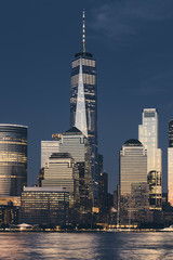 New York City business district skyline at dusk, color toning applied, USA.