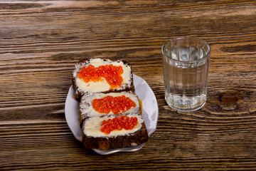 Russian tradition. A glass of vodka and a snack.Sandwiches from black bread with caviar 2