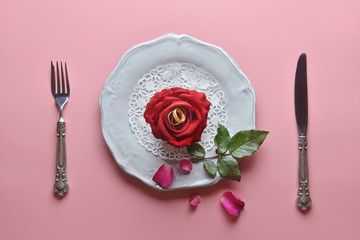 Red rose on white dish, with couple ring inside, On pink background, Concept of Valentine's Day, Romance,  Love, dinner, Special day