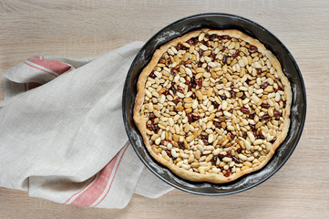 The dough is in the form for an open pie. Beans are used to preserve the shape. Napkin from fabric. There is a place under the text. Light wooden background. View from above.