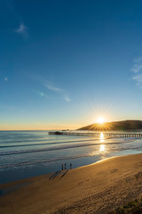 Fototapeta premium Setting Sun on a Coastal town with Pier