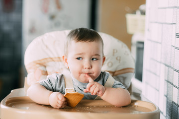 little girl in a high chair eating cookies