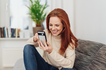Young woman texting a friend with a happy smile