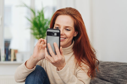 Smiling woman typing in a text message