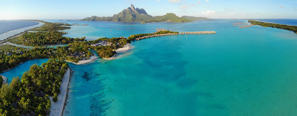 Aerial panoramic landscape view of the island of Bora Bora in French Polynesia with the Mont Otemanu mountain surrounded by a turquoise lagoon, motu atolls, re - obrazy, fototapety, plakaty