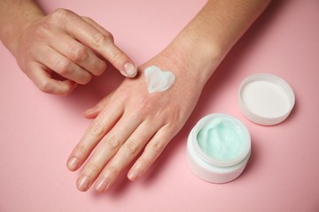Obraz na płótnie Canvas Allergic reaction on skin of hands. Red rash and hand care cream.
