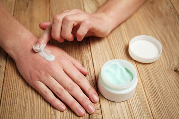 Female hands apply moisturizer to the skin. Irritation and allergies, frostbite.