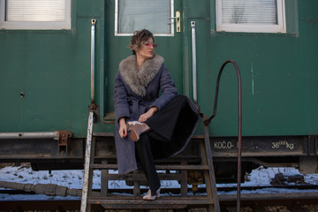young woman in train station at sunny winter day