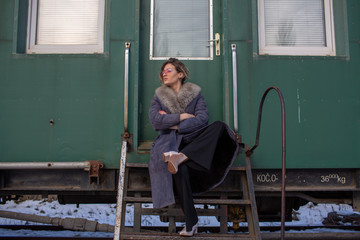 young woman in train station at sunny winter day