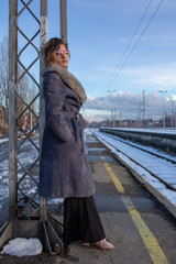 young woman in train station at sunny winter day
