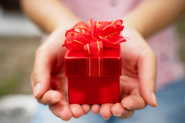 Women give red gift boxes on Valentine's Day.