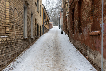 Obraz na płótnie Canvas Riga. Latvia. Winter landscape with pedestrian path between old brick houses.