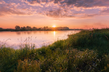 Fototapeta na wymiar Fluss bei Sonnenaufgang - himmelsrot