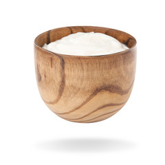 Wooden bowl with delicious sour cream on white background