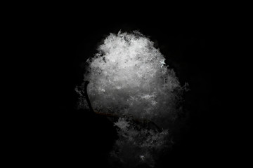 White snow ball made of fluffy snowflakes on a black background