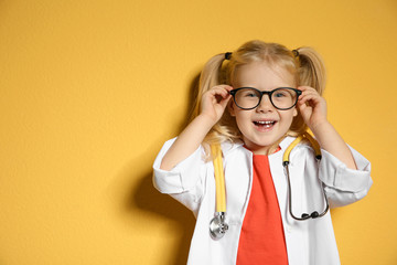 Cute child in doctor coat with stethoscope on color background. Space for text - obrazy, fototapety, plakaty