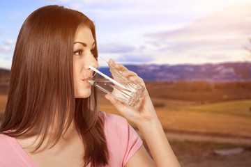 Happy young woman drinking water isolated on white