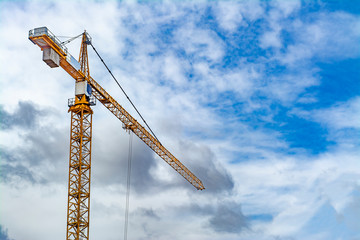 Construction crane against a blue sky and clouds
