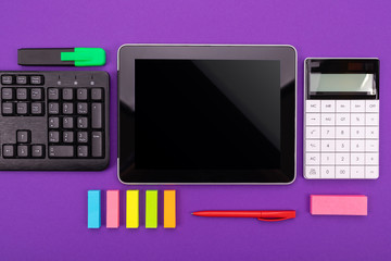 Modern workspace with tablet, keyboard and calculator on purple background. Flat lay concept