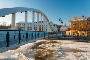 Pedestrian bridge Kaarsild, embankment of Emajõgi river and the view on the Town Hall during winter in Tartu, Estonia