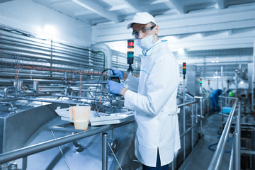 man in a mask and a Bathrobe connects the dosimeter to the dairy Plant