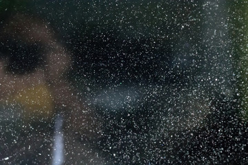 Abstract real dust floating over black background.Dust paricles for overlay use in vintage or grunge design. Blurred dust concept.