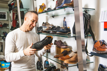 A man are looking for a new shoes in the shoe shop
