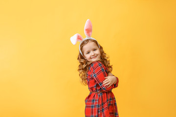 Portrait of a cute little child girl with bunny ears on a colored background. Happy easter