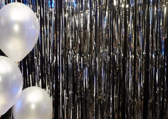 Silver festive background with balloons illuminated by colored lanterns