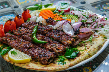 Plate of arabic kebab meat with grilled vegetables.
