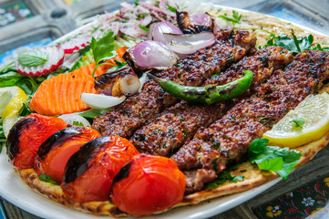 Plate of arabic kebab meat with grilled vegetables.