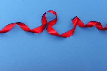 Red ribbon on blue background. Top view