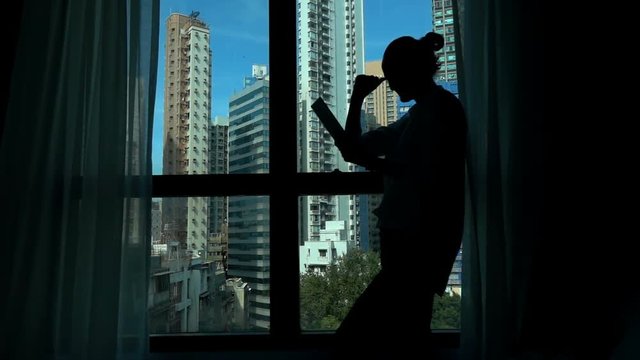 Successful businesswoman with tablet by window in office, super slow motion