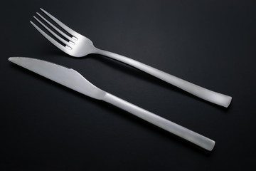 knife and fork on black background