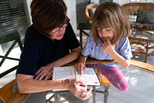 Grandmother and granddaughter doing a math puzzle