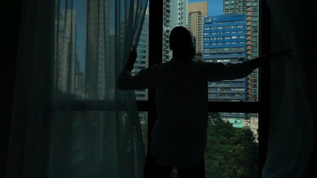 Woman unveil curtain and admire view from window at home, super slow motion