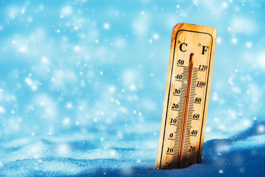 Cold temperature below zero on thermometer in snow