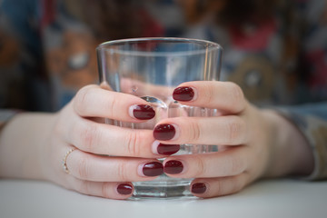 Glass of cold water in a female hands.