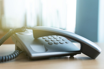 Phone handset laying on the office table. Phone line busy.