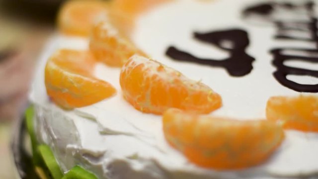 Close up shot of birthday cake with oranges and kiwi