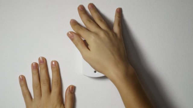 hand push white alarm button on the grey wall. after that turns on red siren lights