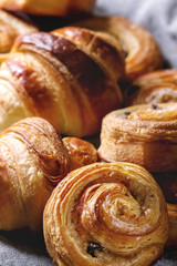 Variety of homemade puff pastry buns cinnamon rolls and croissant. Close up.