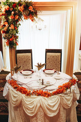 Plates with newlyweds initials stand on the table served for festive dinner