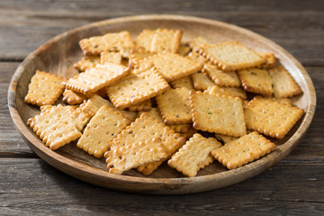 Crackers with cherry jam on a wooden plate on a wooden background. Rustic style