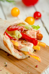 Wrap with cheese, pepper, French fries. Flat lay.