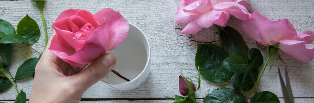 Top view of female decorator arranging roses on the wooden table, Concepts - fiorist, occupation, hobby, small business.
