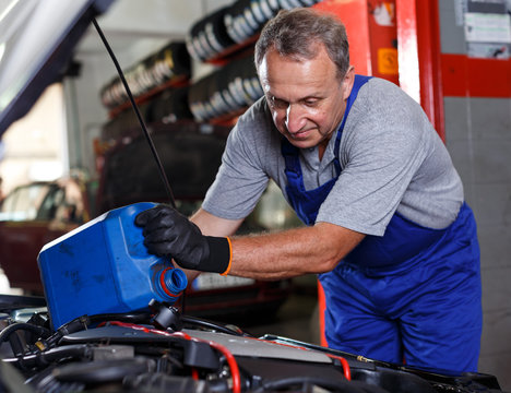 Mechanic engaged in replacement of engine oil