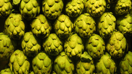 Background of fresh artichokes market green row